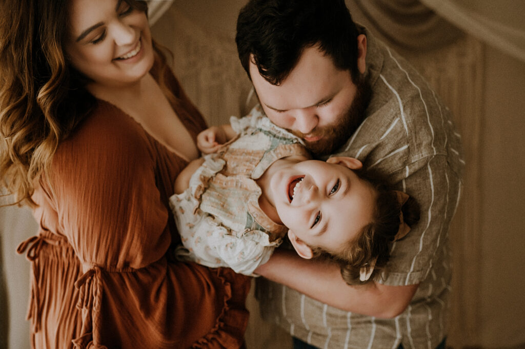 Mom, dad, and young child smiling in Dallas texas.