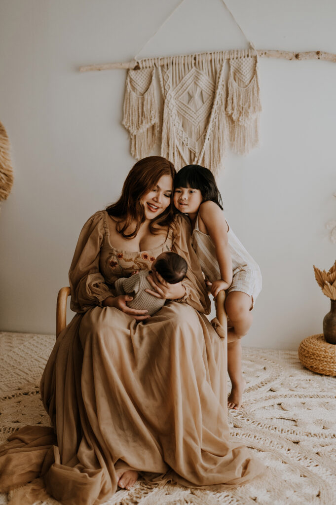 A mom and her toddler son looking at the new baby in a fort worth, texas studio