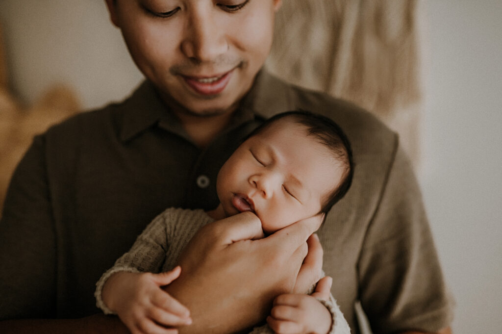 Dad and baby cuddled in Fort Worth Studio