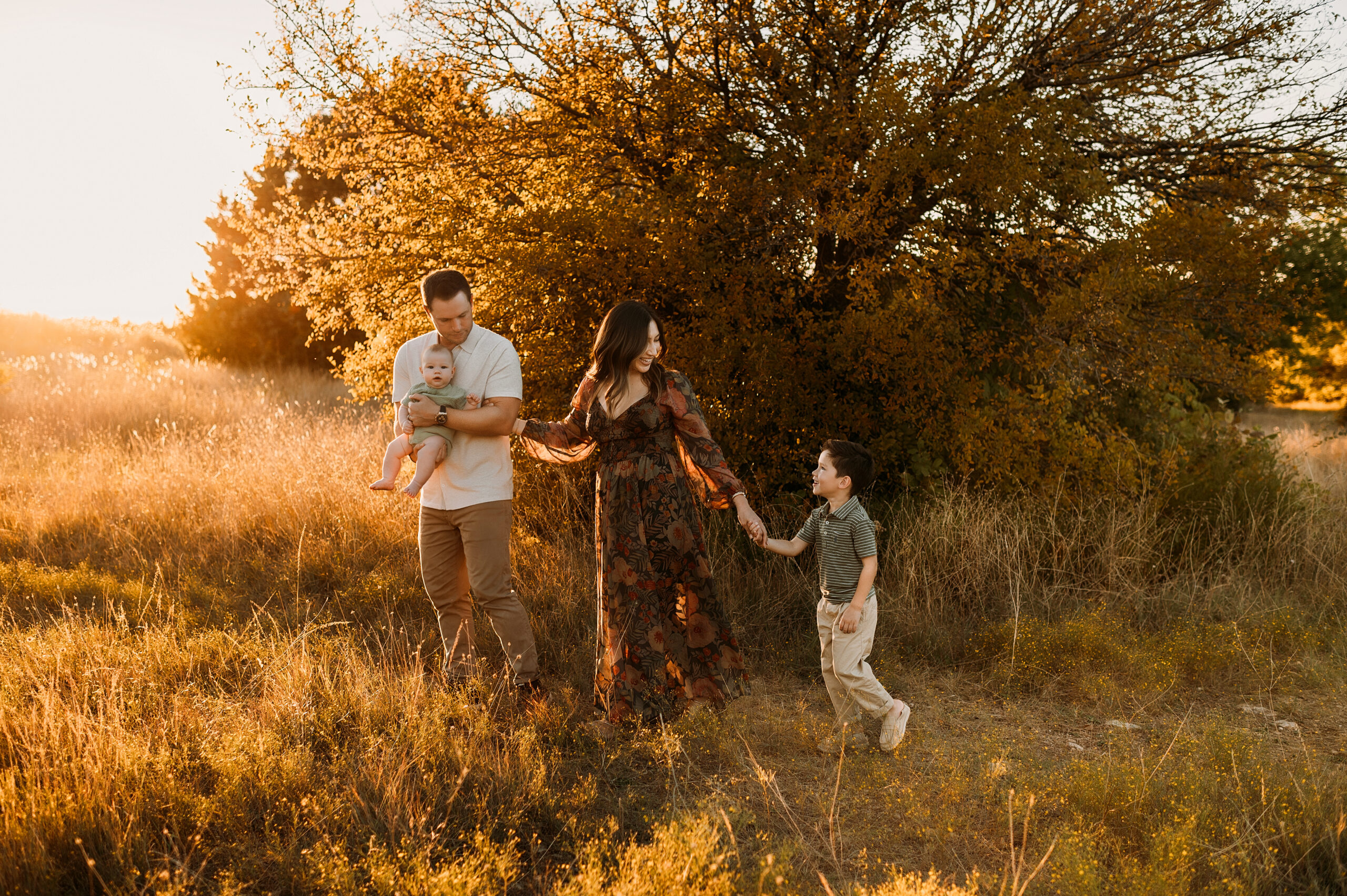 A family of four are holding hands and walking at a dallas park called arbor hills nature preserve