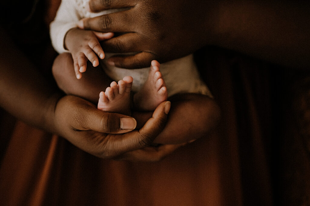 A mom securely holding her baby with a close up shot of baby's toes in fort worth, texas
