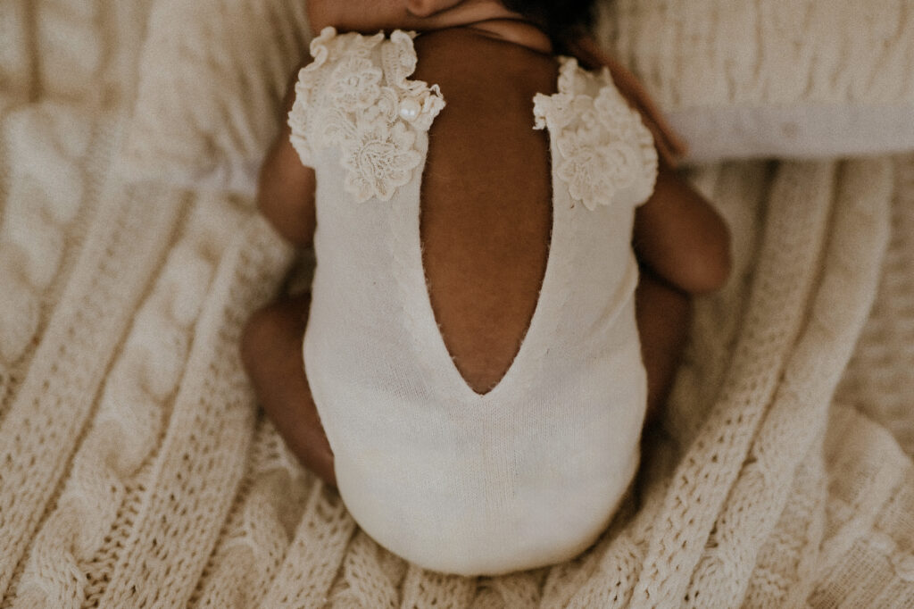 A close up of a newborn. baby and her back laying on a studio bed in fort worth, texas