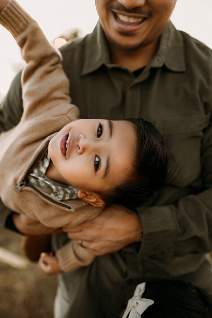A dad holding his little boy in the air in flower mound, texas